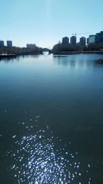 Scenic view of river by city against sky