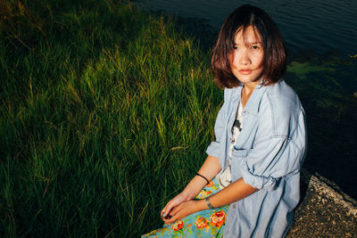 Portrait of woman sitting by lake