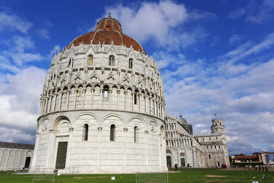 Low angle view of pisa cathedral and dome against cloudy sky