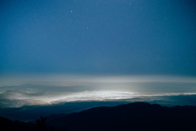 Scenic view of mountains against blue sky