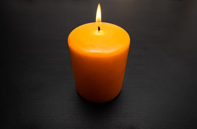 Close-up of orange candle on table