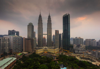 Modern buildings in city against cloudy sky