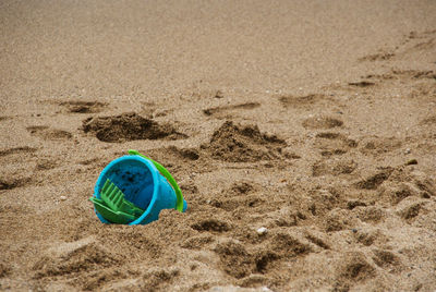 Close-up of bucket on sand at beach