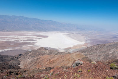 Aerial view of landscape and mountains against blue sky