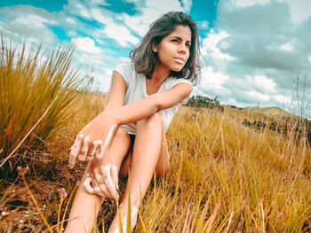 Portrait of smiling young woman on beach against sky