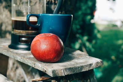 Close-up of apple and mug on table