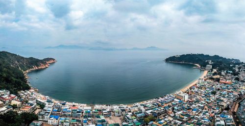 High angle view of city by sea against sky