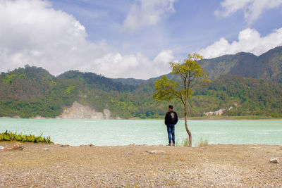 Man standing on beach against sky