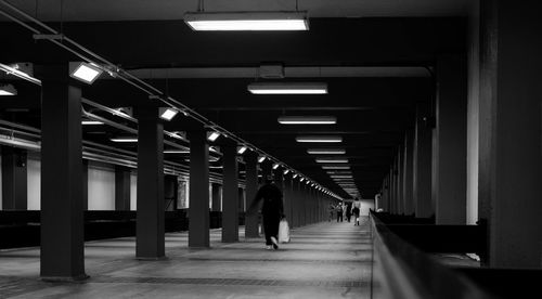 Man walking in illuminated corridor of building