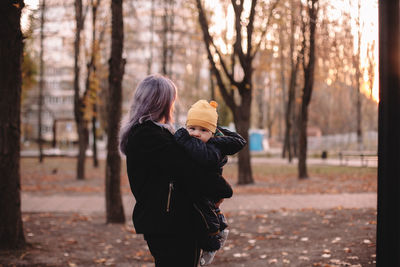 Rear view of women standing in forest during autumn