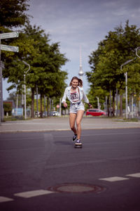 Full length of woman with umbrella on road