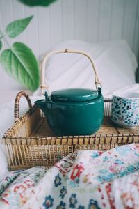 Close up of tea kettle on tray in bed