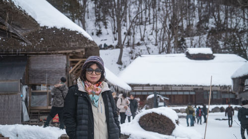 Portrait of smiling young woman standing on snow