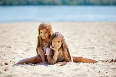 Portrait of young woman sitting at beach