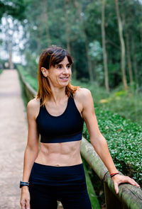 Portrait of woman standing against plants