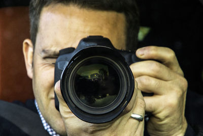 Midsection of man photographing camera