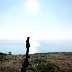 Silhouette man standing on beach against sky
