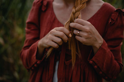 Midsection of woman holding red while standing outdoors