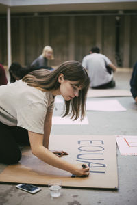 Female protestor preparing signboard in building