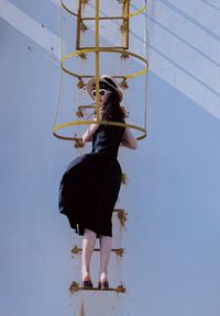 Full length of young woman standing against sky