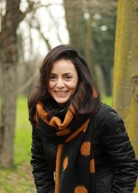 Portrait of smiling woman in forest during winter