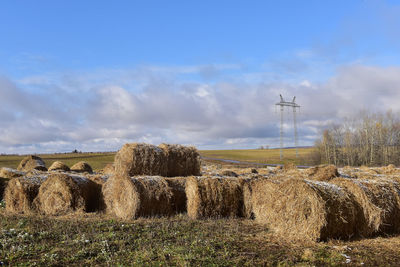 Hay bales on field against sky