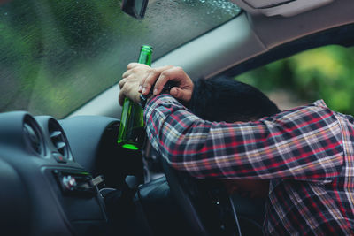 Man holding umbrella in car