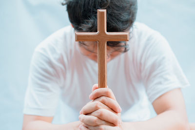 Close-up of man holding cross