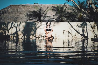 Reflection of young woman in swimming pool 