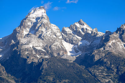 Scenic view of snowcapped mountains against blue sky.  grand teton, wyoming.