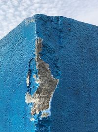 Close-up of weathered rock against blue sky