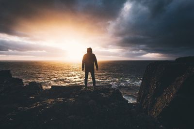 Scenic view of sea against cloudy sky during sunset