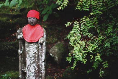 Woman standing by tree trunk