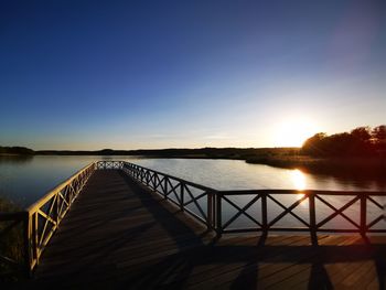 Scenic view of lake against clear sky during sunset