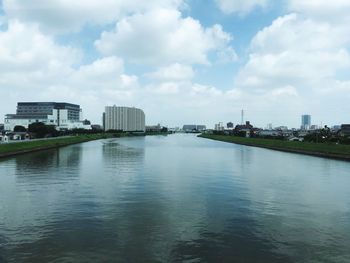 River by buildings in city against sky