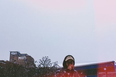 Portrait of young woman against clear sky