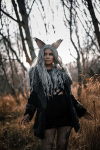 Young woman standing against tree during autumn