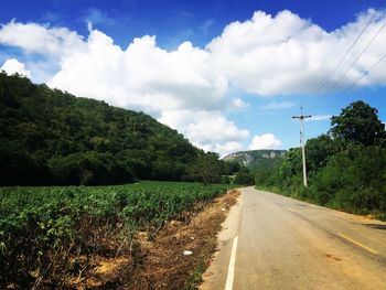 Country road against cloudy sky