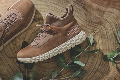 A pair of brown leather waterproof trekking boots on a wooden background. hiking concept.