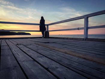 Pier on sea at sunset