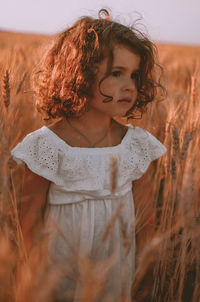 Portrait of cute girl standing on field