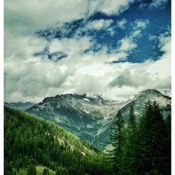 Scenic view of mountains against cloudy sky