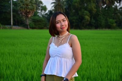 Portrait of beautiful woman standing on field