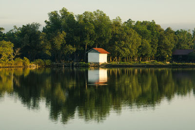 Scenic view of lake by trees against sky