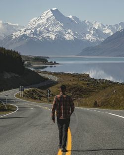 Rear view of man walking on road