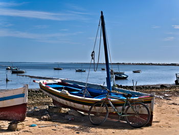 Sailboats moored on beach against sky