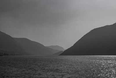 Scenic view of sea and mountains against sky