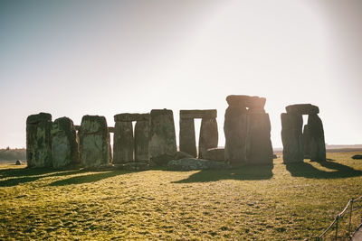 Stone structure on field against clear sky