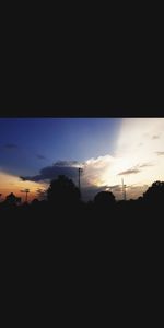 Silhouette landscape against dramatic sky during sunset