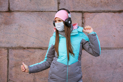 Full length of woman standing against wall